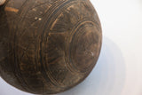 Close-up of antique African carved wooden bowl, incised patterns, old repair, aged patina.