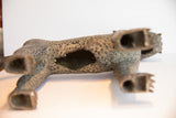 Vintage African leopard casting, underside view with hollow belly and aged, mottled texture.