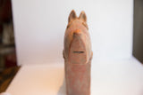 Frontal view of the handmade African terrier sculpture showing its carved face and snout.