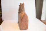 Back profile of the handmade African terrier sculpture showing its upright tail and weathered patina.