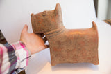 Vintage African terrier sculpture held in hand, showing its scale and rustic texture.