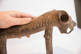 A hand holding the vintage lion dog sculpture, showing its scale and carved mane detail.