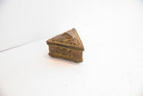 Close-up of vintage African box side, revealing concentric circle motifs and aged patina.