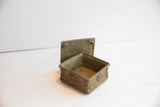 Vintage African square box shown open, revealing its aged, patinated interior.