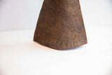Close-up of the heavily rusted and pitted texture on the vintage iron bell.