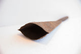 View into the hand-forged, conical opening of a rustic Yoruba iron bell.