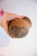 Antique terracotta vase held in hand, showing its palm-sized scale and rustic surface.
