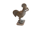 Vintage African rooster sculpture with a snake, showing a textured and oxidized metal finish.