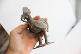 Hand holding the vintage African rooster sculpture to show its scale and patina.