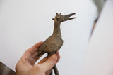 Vintage African bird casting seen in profile, highlighting its rough texture and stylized head.