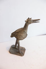 Vintage African bird collectible with a textured body and stylized crown, viewed in profile.
