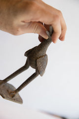 Vintage African bird casting held to show its rustic texture and form.