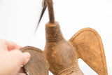 Textured details and etched pattern bands on the back of a vintage African bird casting.