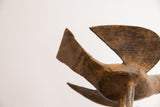 Textured dark brown surface of the vintage African bird casting, showing its aged patina.