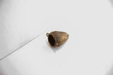 View of the hollow interior and side loop of a handmade woven bronze pendant.