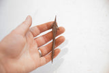 Antique African Yoruba spear point held in hand to illustrate its collectible scale.