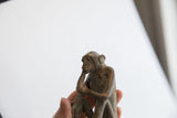 Profile of a vintage African monkey figurine showing its aged, textured surface.