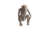 Vintage handmade African monkey figurine in a thoughtful pose with a weathered patina.