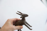 Vintage African antelope sculpture held in hand, showing its textured surface and scale.