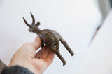 Aged patina and textured surface of a handmade antelope sculpture seen from behind.