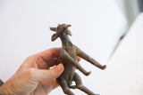 Angled view of a vintage antelope sculpture's head showing textured horns and aged, handmade finish.