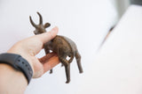 Vintage antelope sculpture held to show the textured detail on its back.