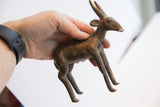 Vintage African antelope sculpture held to show its handmade form and scale.