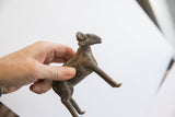 Vintage African ram sculpture held in a hand to demonstrate its scale.