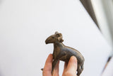 Vintage African ram sculpture held in hand, revealing its aged patina and side profile.