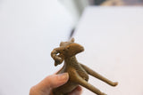 Upward view of the vintage ram sculpture's head, showing its handmade texture and horns.