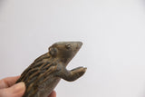 Profile view of the vintage African porcupine sculpture, detailing its face and textured body.