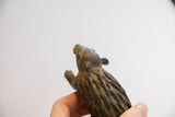 View from below of the vintage porcupine sculpture, highlighting its textured body and face.