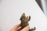 Upward-looking profile of the vintage porcupine sculpture, detailing the aged, textured finish on its face.