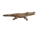 Vintage handmade African alligator sculpture with a textured body holding a fish.