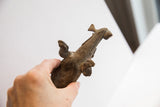 Angled view of the vintage alligator sculpture held in hand, showing scale and texture.