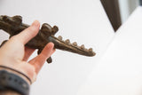 Vintage alligator sculpture held to show its handmade texture and scale.