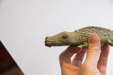 Vintage African alligator sculpture held in hand, showing scale and textured criss-cross design.