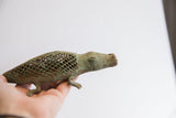 Hand holding the vintage African alligator sculpture to show its side profile and scale.
