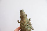 Angled view of the alligator sculpture's textured head and checked open-grid body.