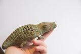 Profile of a vintage alligator sculpture highlighting its checked back and aged patina.