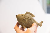 Vintage African fish casting held in hand, showing its scale and texture.