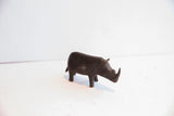 Side profile of a handmade African rhino figurine with a dark, aged patina.