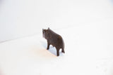 The stout form and tail of the dark patina rhino figurine, viewed from behind.