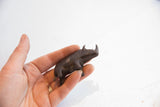 Vintage African rhino figurine held in hand to show its scale and dark patina.