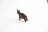 Rear three-quarter view of a handmade African rhino figurine with a dark patina.