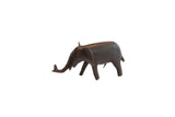 Vintage African elephant figurine with a dark patina, standing in profile with its trunk raised.
