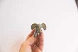 Front view of a vintage elephant figurine showing its oxidized finish and large ears.