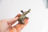 Holding the small African elephant figurine, showing its oxidized finish and shape.