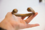 Antique African base cuff bracelet held to show its scale and C-shape.