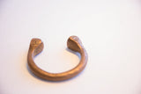 Geometric stamped details on the rounded ends of an antique African copper cuff.